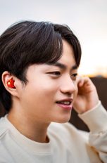 In-Ear-Kopfhörer, Modelle für PlayStation 5, Switch 2 & Co. Eine Person trägt die ‘Glorange’ Arctis GameBuds – limited edition im Ohr.