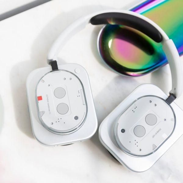 Die Nothing Headphones (1) liegen mit eingedrehten Ohrmuscheln auf einem Tisch.