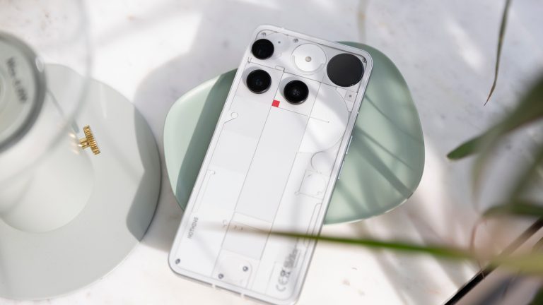 Gesamtansicht der R&uuml;ckseite von einem Nothing Phone (3), das auf einer gr&uuml;nen Schale liegt.