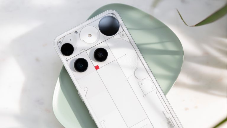 Das Nothing Phone (3) liegt mit der R&uuml;ckseite nach oben auf einer gr&uuml;nen Schale.