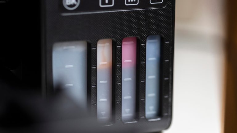 Nahaufnahme der Tintentanks mit den Farben Schwarz, Gelb, Magenta und Cyan eines Epson EcoTank Druckers.