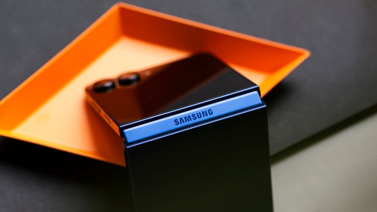 Galaxy-Flip7-38 Ein Samsung Galaxy Z Flip7 steht halb aufgeklappt auf einer orangefarbenen Schale.