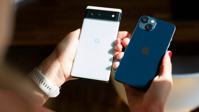Eine Person hält ein Google Pixel und ein iPhone nebeneinander.