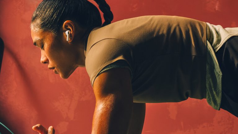Die neuen Apple-Geräte, Series 11, Ultra 3, SE 3 und AirPods Pro 3 Eine Person in Sportkleidung führt einen Plank aus. Sie trägt dabei AirPods Pro 3.