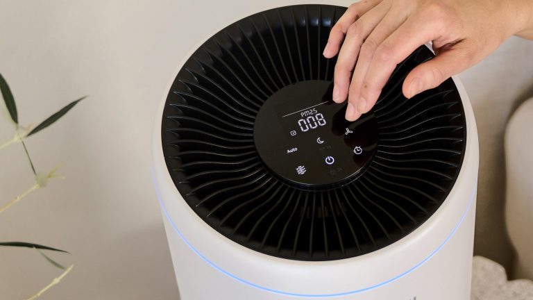 Luftreiniger, 6 Modelle für Allergiker*innen Die Hand einer Person bedient den Bosch Air 200 über das LED-beleuchtete Bedienpanel an seiner Oberseite.