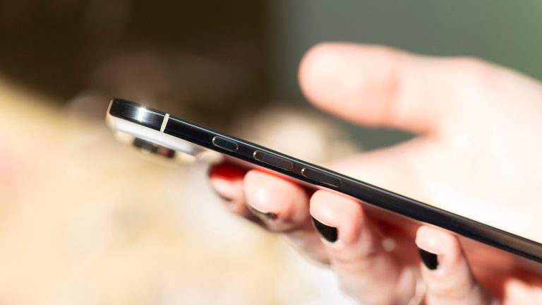 Eine Person h&auml;lt ein iPhone Air in der Hand, das von der Seite zu sehen ist.