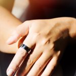 Detailaufnahme einer linken Hand an der ein Smart Ring am Zeigefinger getragen wird.