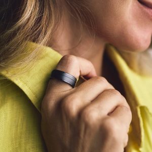 Detailaufnahme der Hand einer Person, die am Zeigefinger der rechten Hand einen Smart Ring trägt.