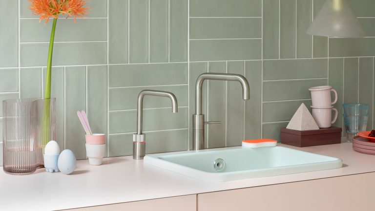 Quooker-Nordic-Twintaps-Square-Voll-Edelstahl Zwei eckige, moderne Nordic Twin Taps in Voll-Edelstahl stehen nebeneinander in einer pastellfarbenen Küche.