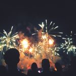 Die Schatten von ein paar Personen vor einem gro&szlig;en n&auml;chtlichen Feuerwerk.