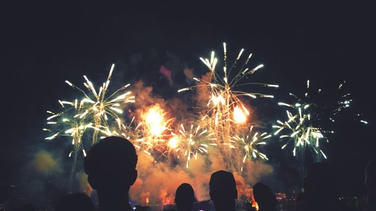 Die Schatten von ein paar Personen vor einem gro&szlig;en n&auml;chtlichen Feuerwerk.