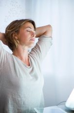 8 Tageslichtlampen, Sonnen-Feeling auch im Winter Eine Tageslichtlampe strahlt eine Person von einem Tisch aus an.