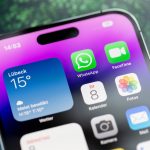 Nahaufnahme eines iPhones, auf dem das WhatsApp-Icon auf dem Homescreen zu sehen ist.
