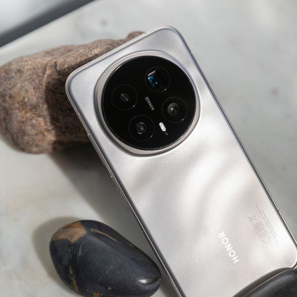 R&uuml;ckseite eines Honor Magic 8 Pro, das angelehnt an ein paar Steine ist.