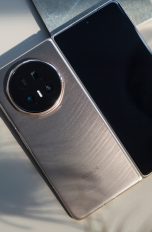Honor Magic V5, So klappt das mit den Foldables Ein Honor Magic V5 liegt aufgeklappt auf einem Tisch neben einem Glas.