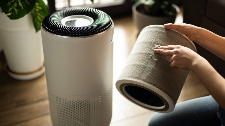 Eine Person h&auml;lt einen Luftfilter in der Hand, der offensichtlich stark mit Staub bedeckt ist.