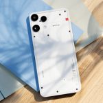 Bild von einem Nothing Phone (3a) Lite, das auf einem Notizbuch auf einem Tisch liegt.