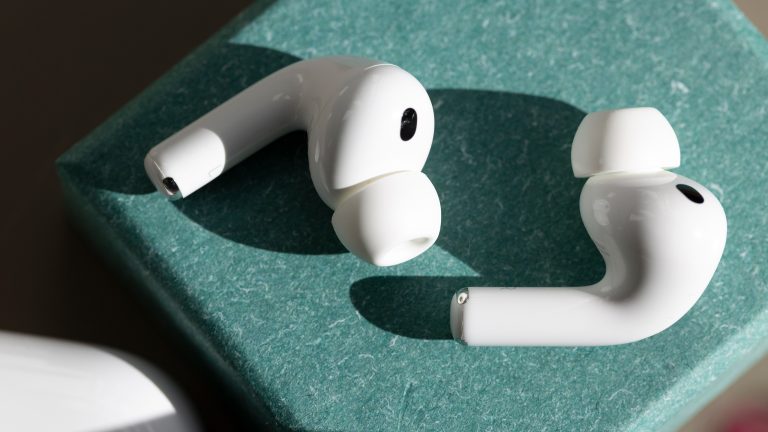Ein linker und ein rechter AirPod Pro liegen einzeln auf einem gr&uuml;nen K&auml;stchen.