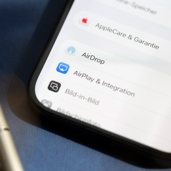 Detailansicht eines iPhones, auf dessen Display die Einstellungen von AirDrop zu sehen sind.