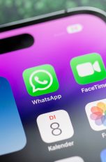 WhatsApp mit Dual-SIM, So funktioniert’s Der obere Teil eines iPhones, das auf einem Tisch liegt. Darauf sind verschiedene Apps, unter anderem WhatsApp zu sehen.