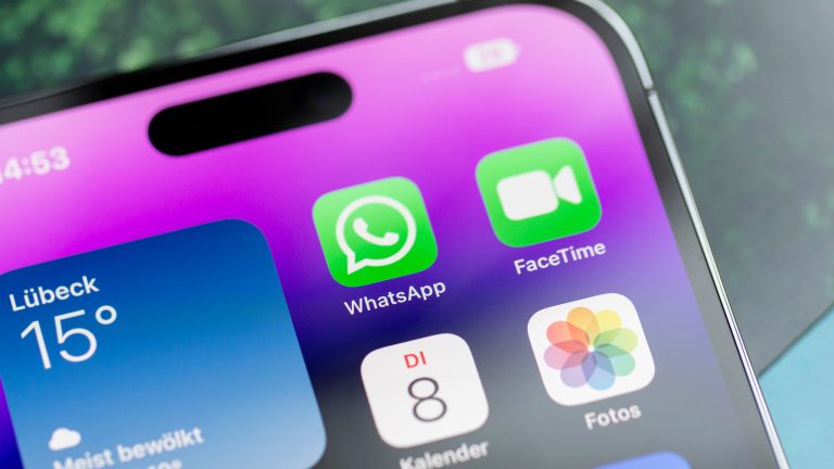 Der obere Teil eines iPhones, das auf einem Tisch liegt. Darauf sind verschiedene Apps, unter anderem WhatsApp zu sehen.