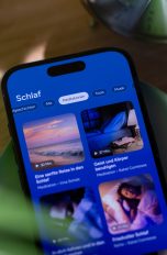 Auf einem iPhone, das auf einer gr&uuml;nen, flachen Schale liegt, ist eine Schlaf-App ge&ouml;ffnet.
