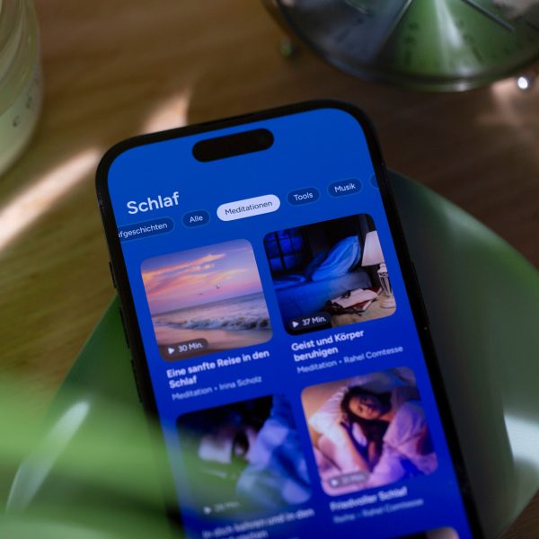 Auf einem iPhone, das auf einer gr&uuml;nen, flachen Schale liegt, ist eine Schlaf-App ge&ouml;ffnet.