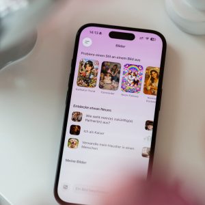 Ein iPhone liegt auf einer wei&szlig;en Oberfl&auml;che. Der Bildschirm ist entsperrt und ein KI-Bildgenerator ist ge&ouml;ffnet.