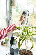 Eine Person reinigt mit einem elektrischen Fenstersauger ein Fenster in ihrem Zuhause.