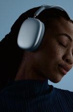 AirPods Max 2, H2Chip, stärkeres ANC und smarte Features Eine Person trgät die AirPods Max 2 auf dem Kopf und hört mit geschlossenen Augen Musik.