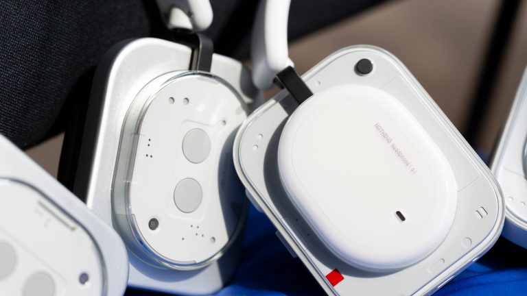 Die Nothing Headphone (1) stehen aufrecht links neben den Headphone (a).