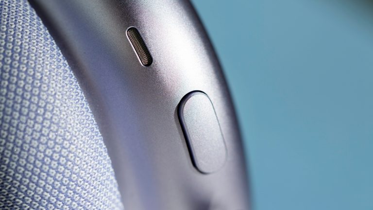 AirPods Max 2, Kopfhörer mit unverkennbarer Apple-DNA im Praxistest Blick auf Knopf und Mikrofon bei den AirPods Max 2 in Violett.