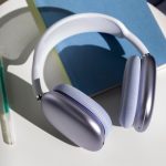 (Die AirPods Max 2 in der Farbe Violett liegen auf einem Notizbuch, daneben liegt ein Stift.)