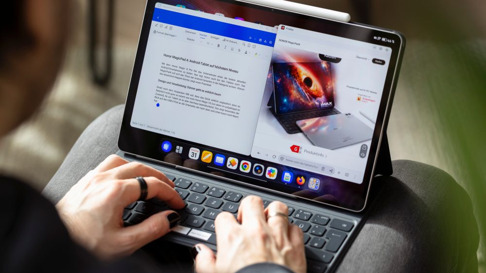 Eine Person tippt auf der Tastatur eines Honor MagicPad 4, auf dessen Bildschirm ein Textdokument ge&ouml;ffnet ist.