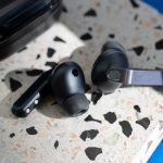 Zwei einzelne Samsung Galaxy Buds4 Pro liegen auf einer bunt gesprenkelten Oberfl&auml;che.&nbsp;