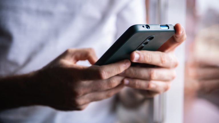 Detailaufnahme von H&auml;nden einer Person, die ein Android-Smartphone bedienen.
