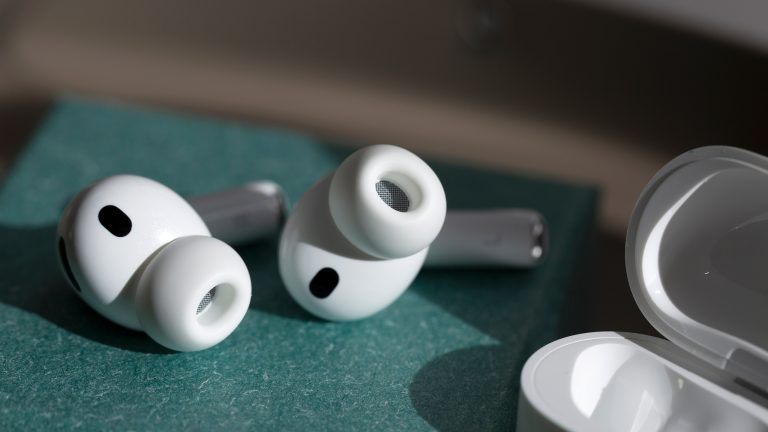 Kopfhörer, Welche Arten es gibt und wann sie glänzen Die AirPods Pro 3 liegen auf einer grünen Oberfläche, daneben ist das Ladecase zu sehen.