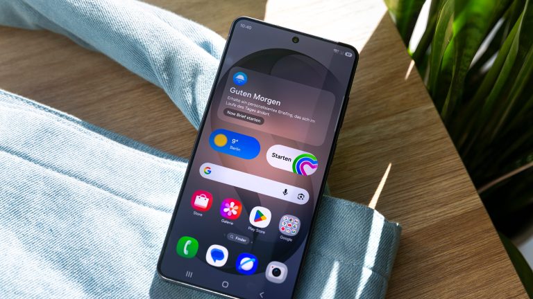 Blick auf ein Android-Smartphone mit eingeschaltetem Display auf dem der Homescreen zu sehen ist.