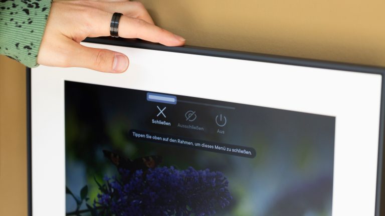 Aura Walden, Ein wirklich ansehnlicher digitaler Bilderrahmen Eine Person hält ihren Finger über die Touch-Leiste an der Oberseite eines Aura Walden.