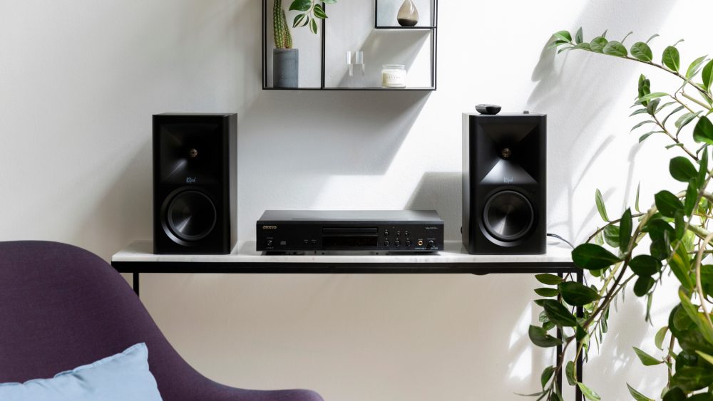 Die Klipsch The Fives II stehen auf einem kleinen Tisch neben einem CD-Player von Onkyo.