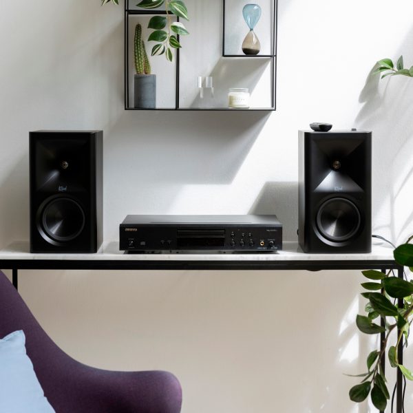 Die Klipsch The Fives II stehen auf einem kleinen Tisch neben einem CD-Player von Onkyo.