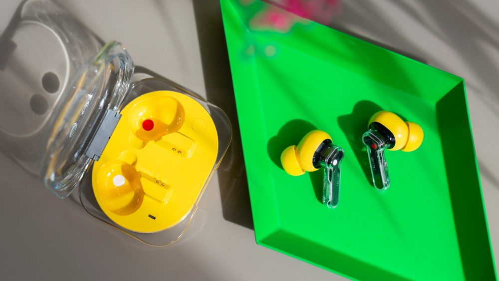 Die Nothing Ear (3a) liegen au&szlig;erhalb ihres Ladecases in einer gr&uuml;nen Schale.