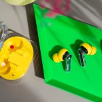 Die Nothing Ear (3a) liegen au&szlig;erhalb ihres Ladecases in einer gr&uuml;nen Schale.