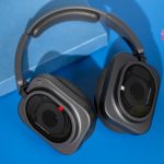 Blick auf die Nothing Headphone (1) Pro, die leicht eingeklappt auf einem blauen Untergrund liegen.