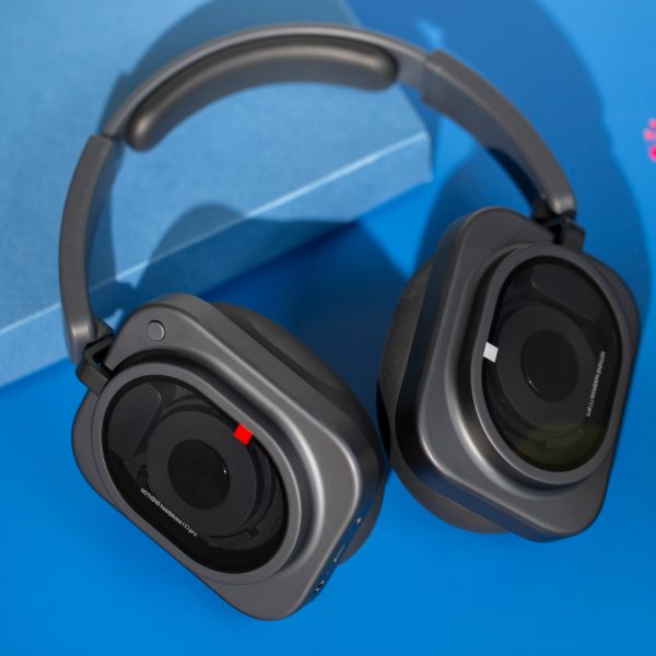 Blick auf die Nothing Headphone (1) Pro, die leicht eingeklappt auf einem blauen Untergrund liegen.