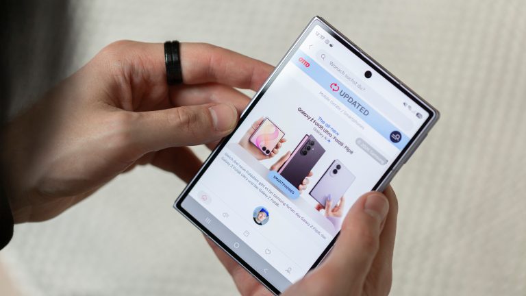 Eine Person h&auml;lt ein zugeklapptes Galaxy Z Fold8 in der Hand. Darauf ist die Website OTTO UPDATED zu sehen.
