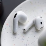 Zwei AirPods5 liegen auf einem weißen Untergrund.