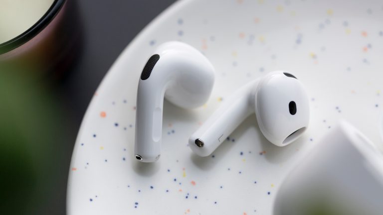 Zwei AirPods5 liegen auf einem weißen Untergrund.
