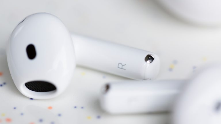 Apple AirPods 5 im Praxistest, Was können die neuen AirPods wirklich? Im Fokus steht ein rechter AirPod 5, der auf der Seite auf einem weißen Hintergrund liegt. Daneben liegt leicht verschwommen im Bild, der linke AirPod.