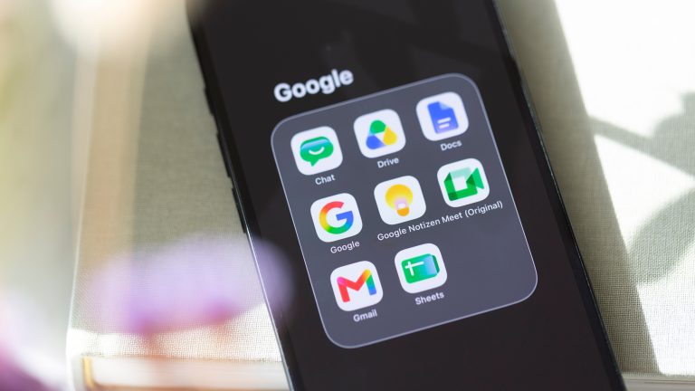 Smartphone mit mehreren Google-Apps auf dem Bildschirm.